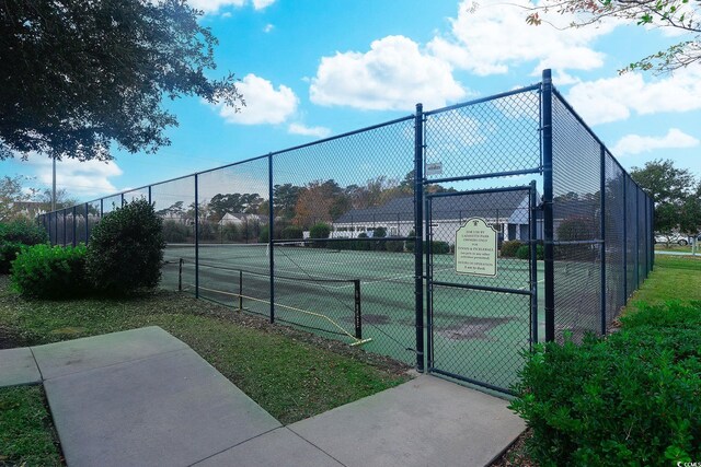 view of tennis court with fence and a gate