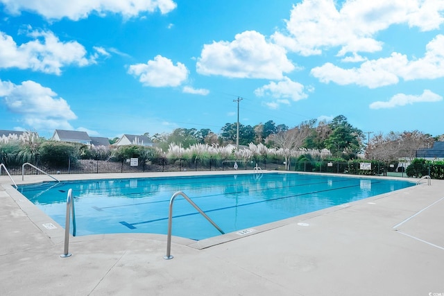 view of swimming pool featuring fence