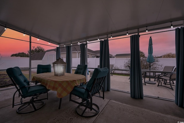 view of patio featuring a shed, an outdoor structure, a fenced backyard, and outdoor dining space