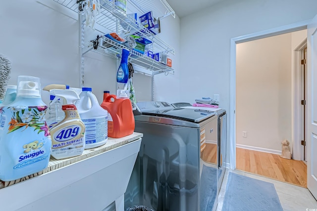 washroom with light wood-style floors, washing machine and dryer, and laundry area