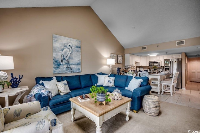 living area featuring high vaulted ceiling, visible vents, and light tile patterned flooring