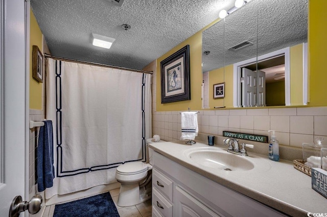 full bathroom with tile patterned flooring, tile walls, a textured ceiling, and vanity