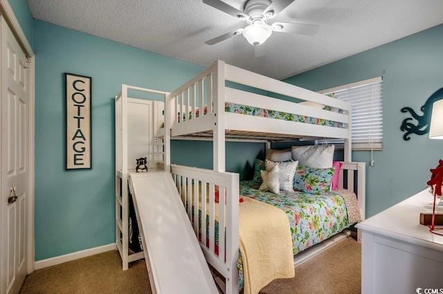 carpeted bedroom with ceiling fan, baseboards, and a textured ceiling