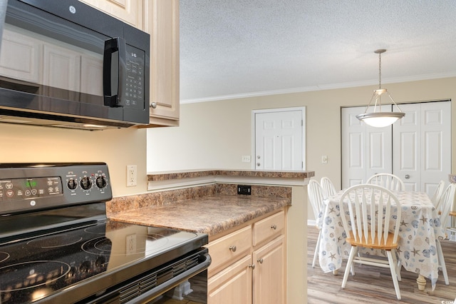 kitchen featuring crown molding, light wood finished floors, dark countertops, a textured ceiling, and black appliances