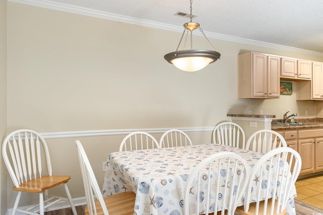 dining room with a textured ceiling, ornamental molding, and visible vents