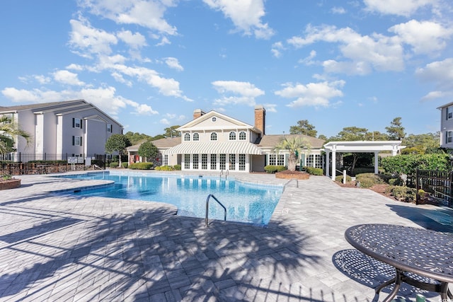 community pool featuring a patio area and fence