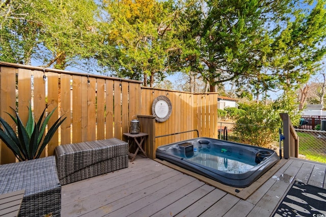 deck featuring fence and hot tub deck surround