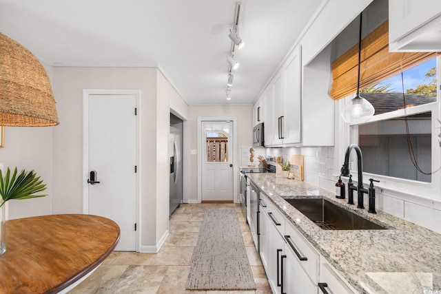 kitchen featuring a sink, light stone counters, backsplash, white cabinetry, and appliances with stainless steel finishes