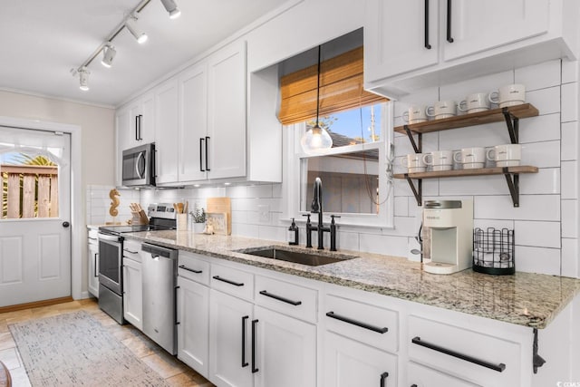 kitchen featuring a sink, stainless steel appliances, backsplash, and a wealth of natural light