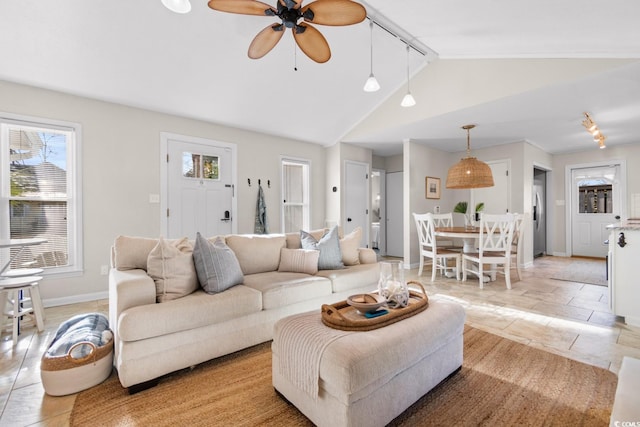 living room featuring a ceiling fan, baseboards, and high vaulted ceiling