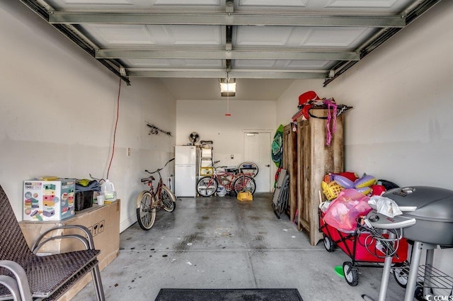 garage with a garage door opener and freestanding refrigerator