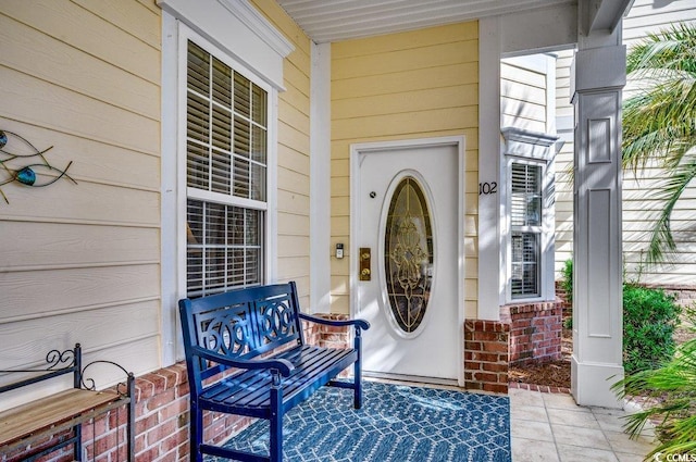 doorway to property featuring brick siding