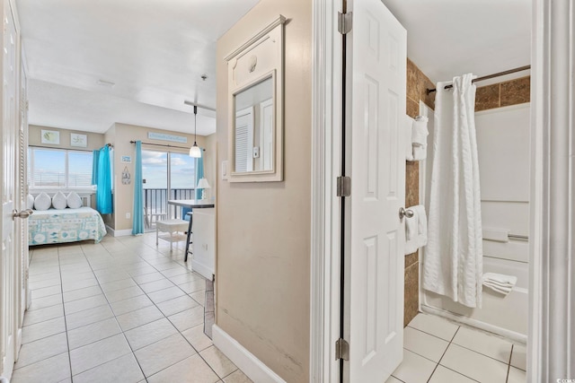 hallway featuring light tile patterned floors and baseboards