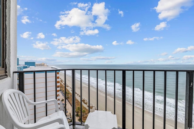 balcony with a water view and a view of the beach