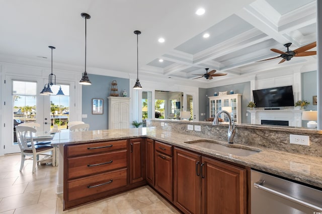 kitchen featuring decorative light fixtures, a sink, and light stone countertops