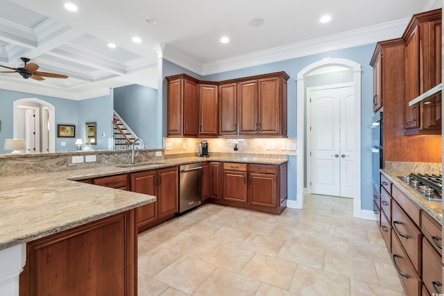 kitchen with arched walkways, brown cabinetry, appliances with stainless steel finishes, light stone countertops, and a sink