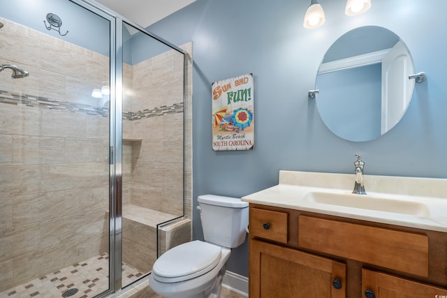 bathroom with a stall shower, vanity, and toilet