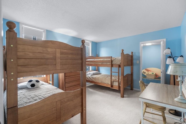 bedroom featuring carpet flooring, a textured ceiling, and baseboards