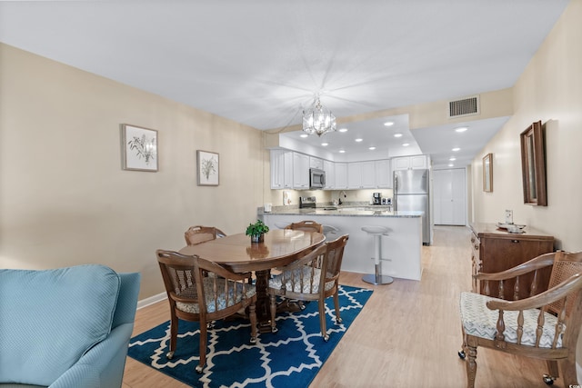 dining room featuring baseboards, visible vents, light wood-style floors, a notable chandelier, and recessed lighting