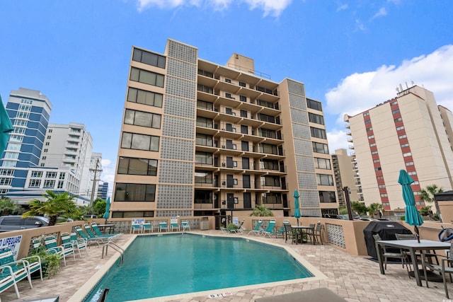 community pool with a patio area and fence