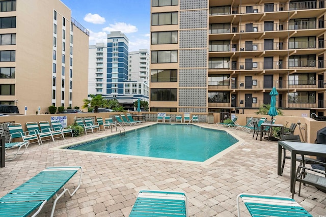 pool with a patio area and a city view