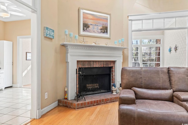 living room with a fireplace, baseboards, and wood finished floors