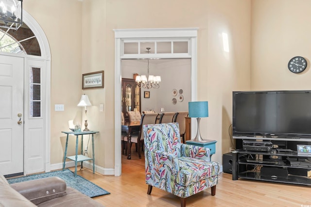 interior space with a chandelier, wood finished floors, and baseboards