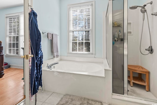 bathroom featuring a stall shower, a garden tub, and tile patterned floors