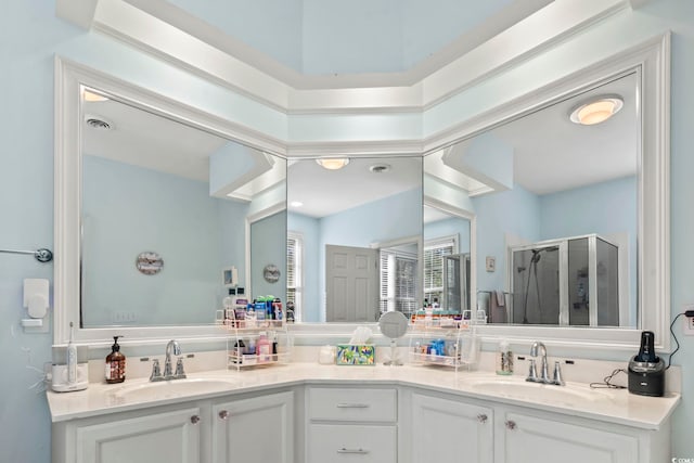 bathroom with double vanity, a stall shower, visible vents, and a sink