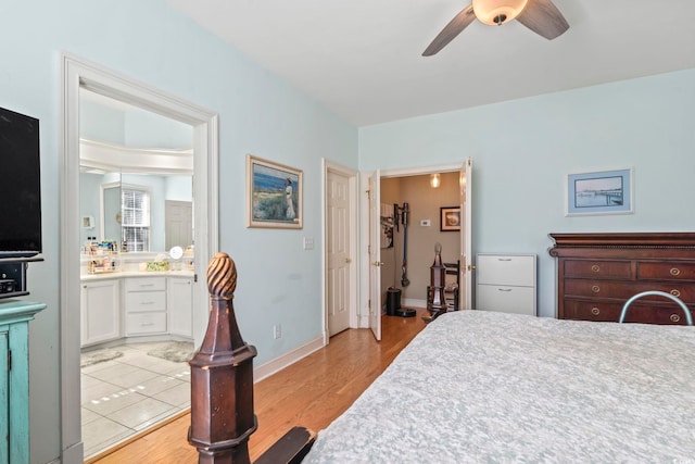 bedroom with baseboards, ceiling fan, ensuite bath, and light wood-style floors