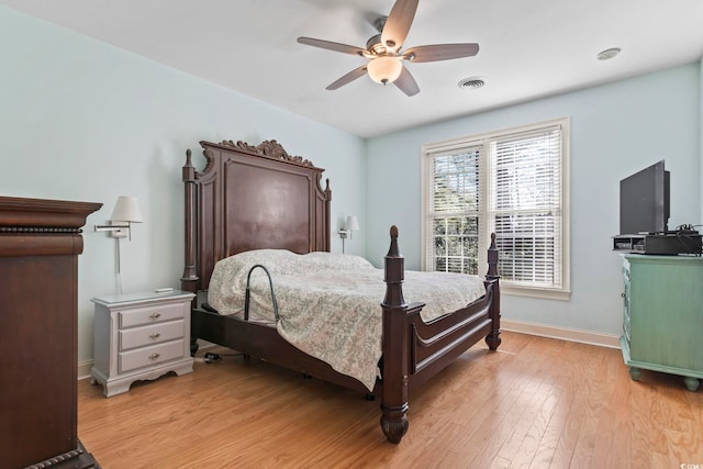 bedroom featuring a ceiling fan, light wood-type flooring, visible vents, and baseboards