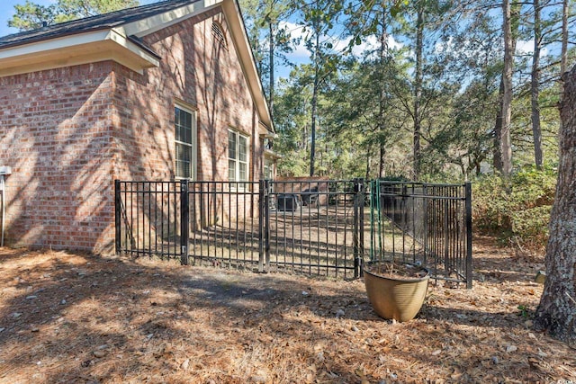 view of home's exterior featuring fence, a patio, and brick siding