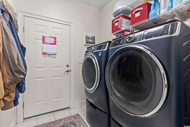 laundry room featuring laundry area, light tile patterned floors, baseboards, and washer and dryer