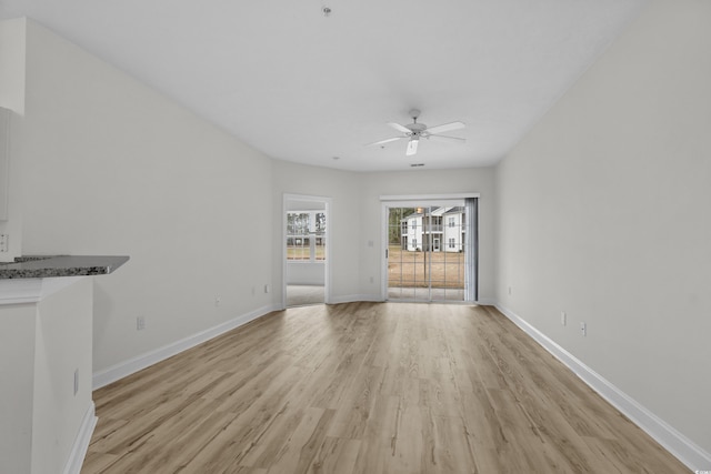 unfurnished living room with baseboards, ceiling fan, and light wood-style floors