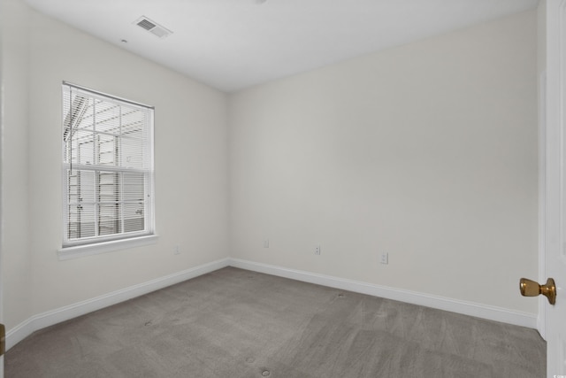 empty room featuring light carpet, baseboards, and visible vents