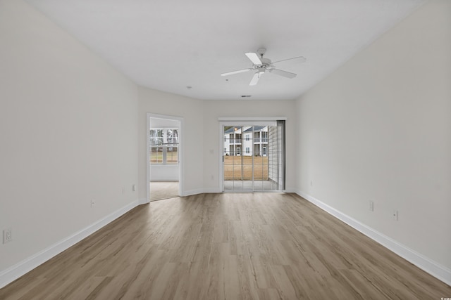 empty room with a ceiling fan, baseboards, visible vents, and light wood finished floors