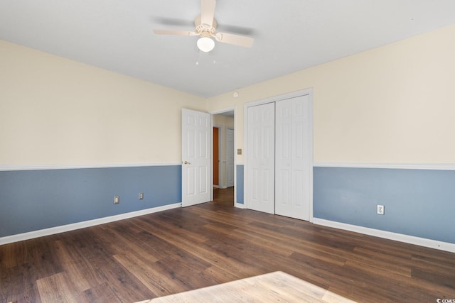 unfurnished bedroom with dark wood-style floors, ceiling fan, a closet, and baseboards