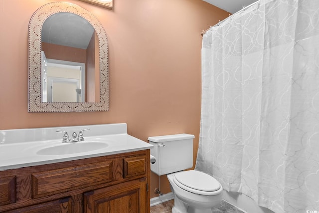 bathroom featuring baseboards, vanity, and toilet