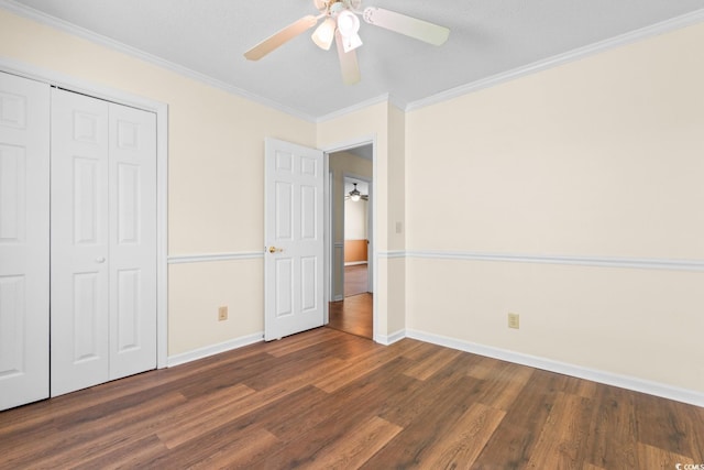 unfurnished bedroom featuring baseboards, a closet, ornamental molding, and dark wood-type flooring