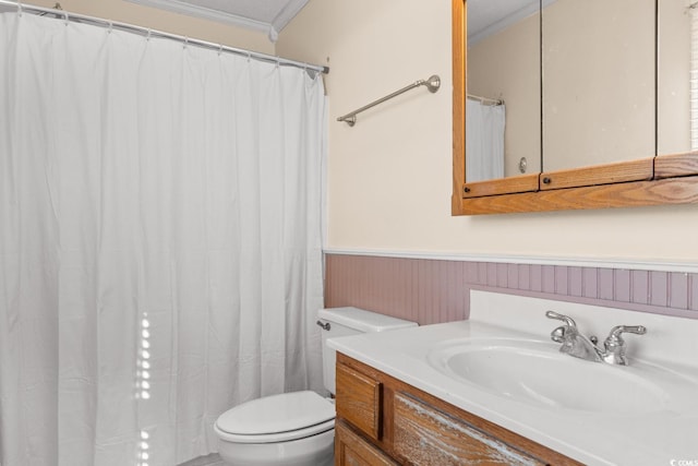 full bath with toilet, a wainscoted wall, crown molding, and vanity