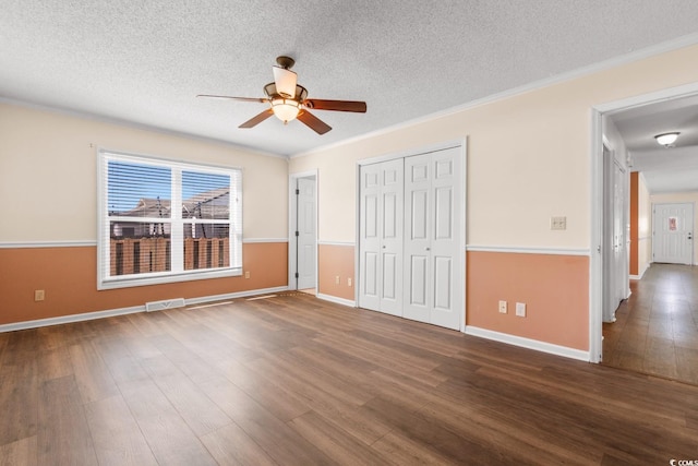 unfurnished bedroom with crown molding, a textured ceiling, and wood finished floors