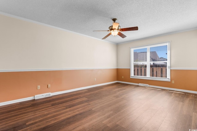 empty room with visible vents, dark wood-style flooring, and ornamental molding