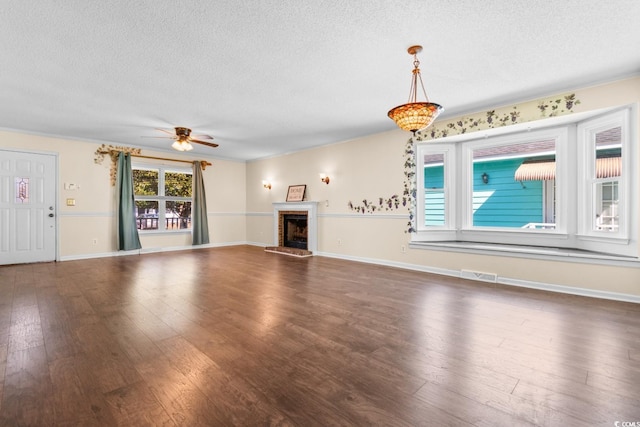 unfurnished living room with a textured ceiling, a fireplace, visible vents, and dark wood-type flooring