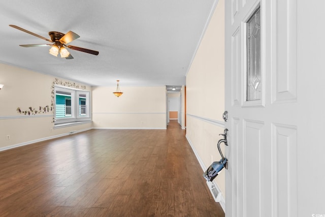 interior space featuring ceiling fan, baseboards, dark wood finished floors, and a textured ceiling