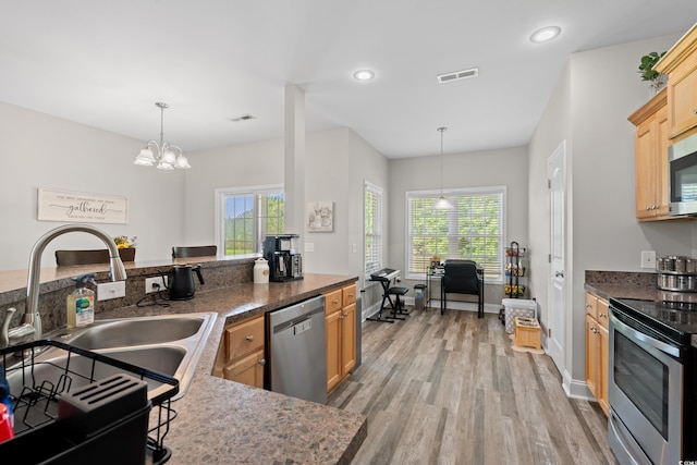 kitchen featuring stainless steel appliances, light wood-style flooring, healthy amount of natural light, a sink, and recessed lighting