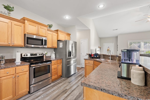 kitchen featuring stainless steel appliances, a sink, light wood finished floors, a ceiling fan, and recessed lighting