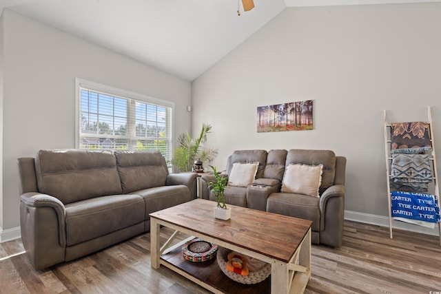 living area with high vaulted ceiling, wood finished floors, ceiling fan, and baseboards
