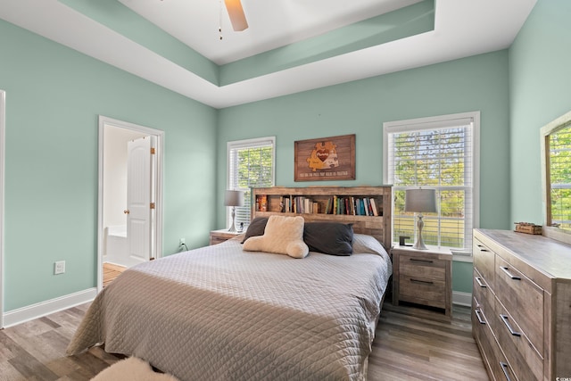 bedroom featuring dark wood-style floors, multiple windows, and baseboards