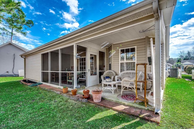 rear view of house featuring a yard, a sunroom, and central air condition unit