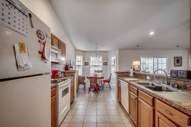 kitchen with pendant lighting, light tile patterned floors, visible vents, a sink, and white appliances